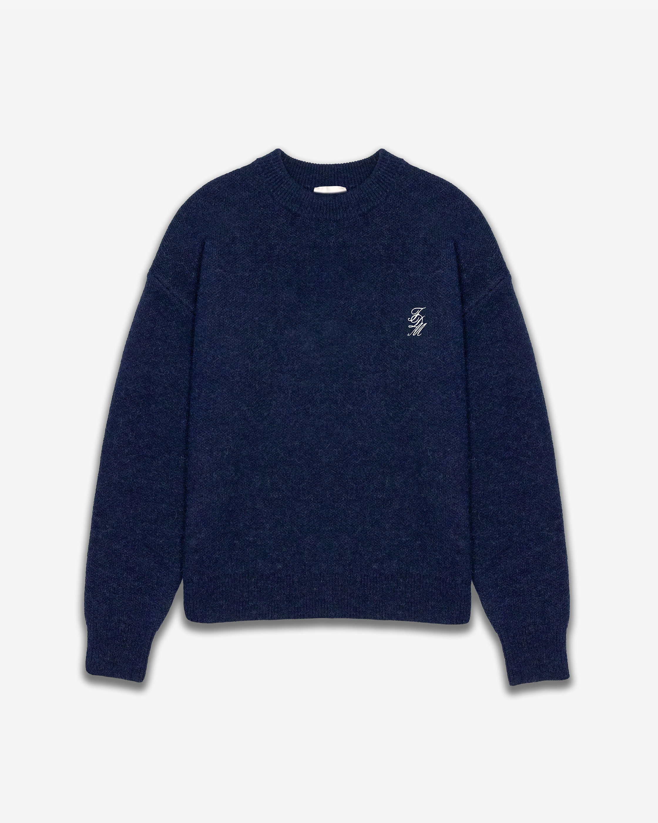 Navy blue sweater with a small white logo on a light gray background