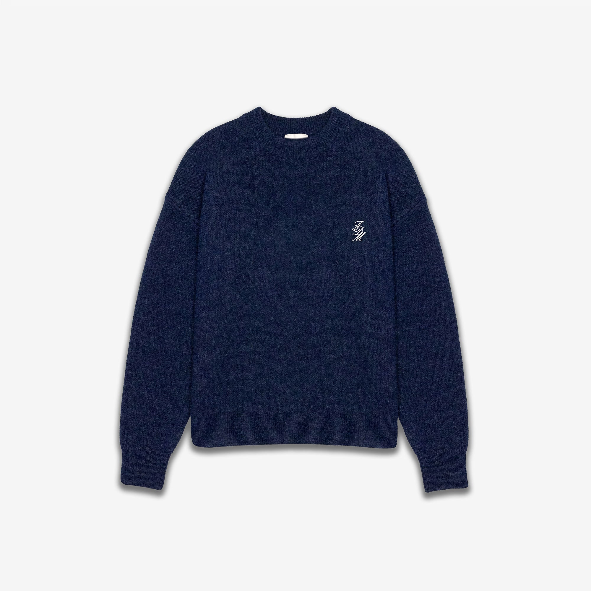 Navy blue sweater with a small white logo on a light gray background