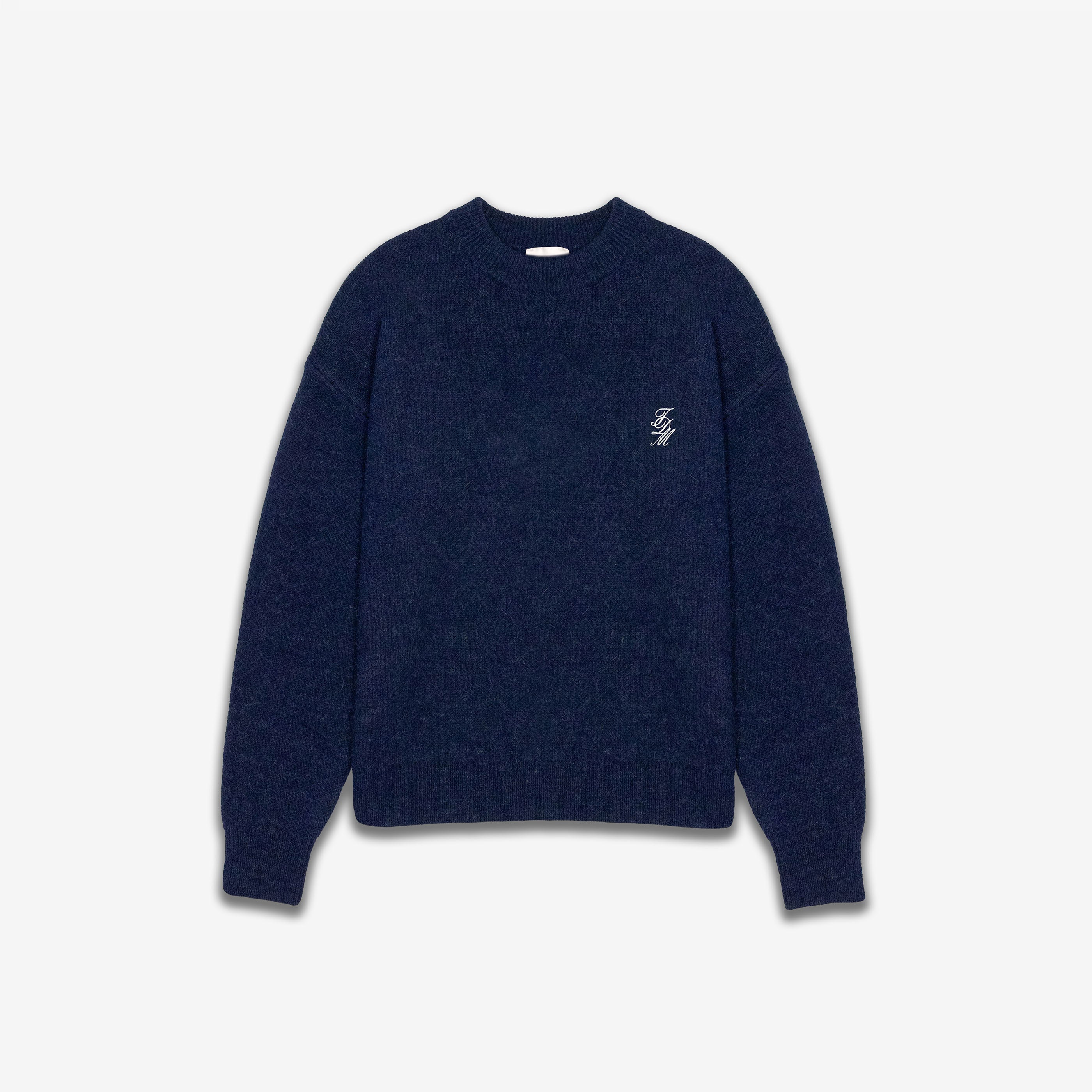 Navy blue sweater with a small white logo on a light gray background